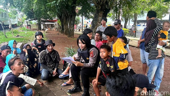 Briptu Karin Polwan Sat Samapta Polres Karawang tengah mentraktir berbuka para tuna wisma di samping rel kereta