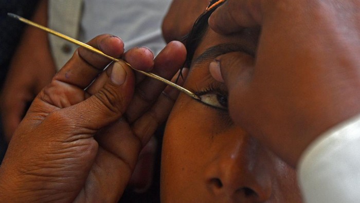 Celak Mata, Tradisi yang Lestari untuk Pria Muslim Nepal Nepali Muslim apply traditional Kohl eyeliner before offering Eid prayers at the start of the Eid al-Fitr holiday marking the end of Ramadan at the Kashmiri Mosque in Kathmand on June 16, 2018. - Muslims around the world are celebrating Eid al-Fitr which marks the end of the month of Ramadan, after the sighting of the new crescent moon. (Photo by PRAKASH MATHEMA / AFP)        (Photo credit should read PRAKASH MATHEMA/AFP via Getty Images)