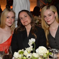 Dakota Fanning mengenakan busana yang cukup berisiko, karena aksen bunga anthurium hanya menutupi sebagian kecil dadanya. Sepatu emas dari Jimmy Choo melengkapi penampilannya. Foto: Getty Images