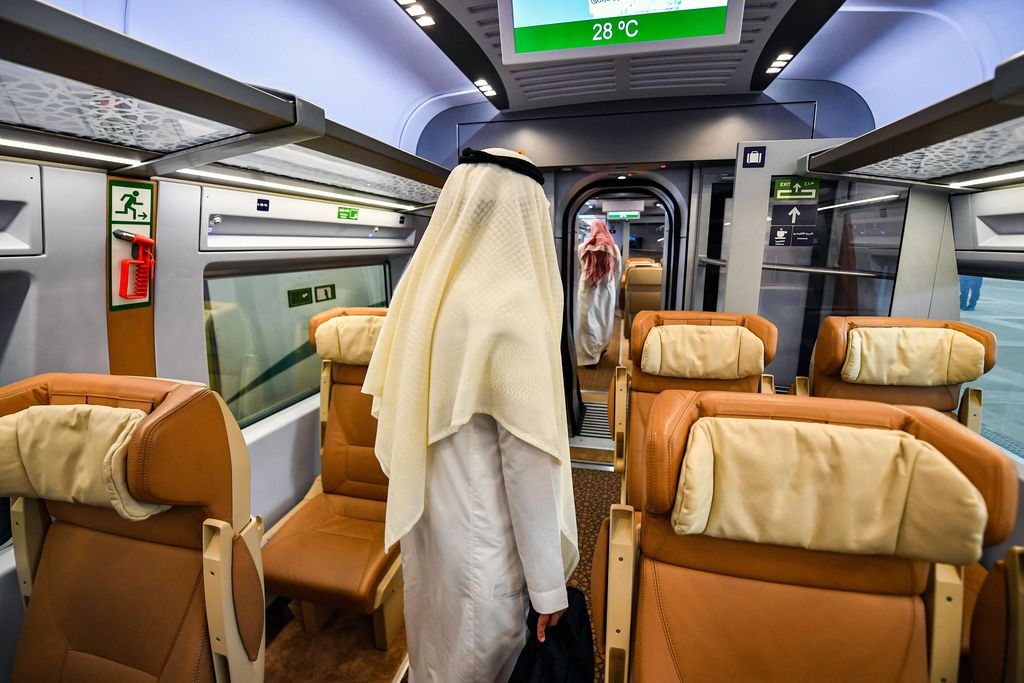 Men walk through a carriage of a Haramain High Speed train, part of a network linking Saudi Arabia's two Muslim holy cities of Mecca and Medina, while at the airport station in the Red Sea city of Jeddah on December 12, 2019. - The high-speed railway, inaugurated by King Salman in September 2018, runs 450 kilometres (280 miles) via the Red Sea port of Jeddah, shuttling passengers at speeds of up to 300 kilometres per hour. Officials had described it as the biggest transport project in the region. Saudi is boosting its infrastructure spending and expanding its railways as it seeks to diversify its oil-dependent economy. (Photo by GIUSEPPE CACACE / AFP) (Photo by GIUSEPPE CACACE/AFP via Getty Images)