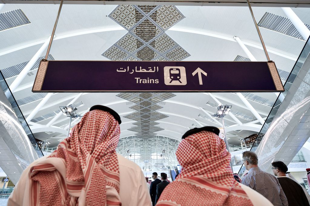 People walk on the platform of the Haramain High Speed Rail Network, Saudi Arabia's two Muslim holy cities of Mecca and Medina, at the airport station in the Red Sea city of Jeddah on December 12, 2019. - The high-speed railway, inaugurated by King Salman in September 2018, runs 450 kilometres (280 miles) via the Red Sea port of Jeddah, shuttling passengers at speeds of up to 300 kilometres per hour. Officials had described it as the biggest transport project in the region. Saudi is boosting its infrastructure spending and expanding its railways as it seeks to diversify its oil-dependent economy. (Photo by GIUSEPPE CACACE / AFP) (Photo by GIUSEPPE CACACE/AFP via Getty Images)