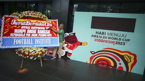 Petugas membawa karangan bunga di GBK Arena, Jakarta, Kamis (30/3/2023). Karangan bunga tersebut merupakan bentuk dukungan sekaligus kekecewaan berbagai pihak setelah batalnya Indonesia menjadi tuan rumah Piala Dunia U-20 2023. ANTARA FOTO/Rivan Awal Lingga/nym.