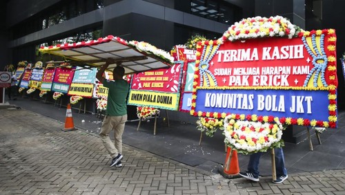 Petugas membawa karangan bunga di GBK Arena, Jakarta, Kamis (30/3/2023). Karangan bunga tersebut merupakan bentuk dukungan sekaligus kekecewaan berbagai pihak setelah batalnya Indonesia menjadi tuan rumah Piala Dunia U-20 2023. ANTARA FOTO/Rivan Awal Lingga/nym.
