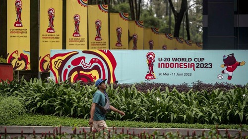 Warga berjalan di dekat papan promosi Piala Dunia U-20 Indonesia 2023 di kawasan GBK Arena, Jakarta, Kamis (30/3/2023). FIFA resmi mencabut status Indonesia sebagai tuan rumah untuk gelaran Piala Dunia U-20 2023 mendatang.