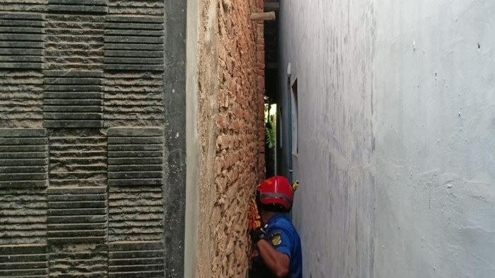 Petugas Damkar Pekalongan mengevakuasi warga yang terjepit lorong rumah, Kamis (30/3/2023).