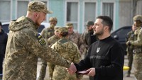 Zelenskyy menyerahkan medali kepada seorang prajurit di Okhtyrka di wilayah Sumy Ukraina.  