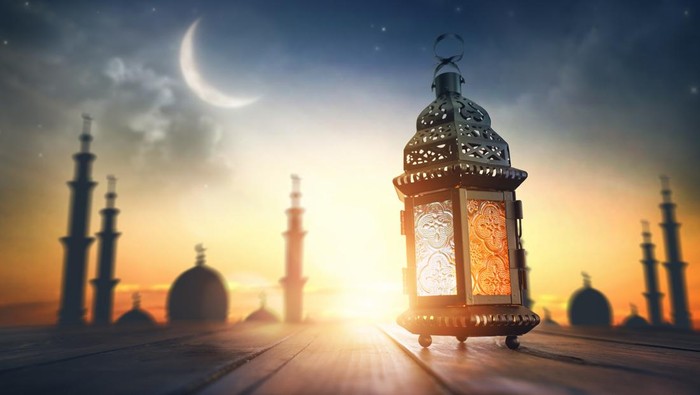 Ornamental Arabic lantern with burning candle glowing at night. Festive greeting card, invitation for Muslim holy month Ramadan Kareem.