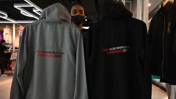 Seorang wanita memegang merchandise resmi untuk turnamen sepak bola Piala Dunia FIFA U-20 Indonesia 2023 di sebuah toko di Jakarta pada 30 Maret 2023. - FIFA mengumumkan pada 29 Maret telah menghapus Indonesia sebagai tuan rumah Piala Dunia U-20 tahun ini di tengah politik kekacauan atas partisipasi Israel. (ADEK BERRY/AFP via Getty Images)