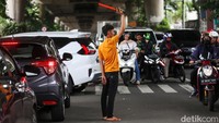 Tukang parkir liar atau Pak Ogah kembali turun dan menguasai U-turn tersebut.