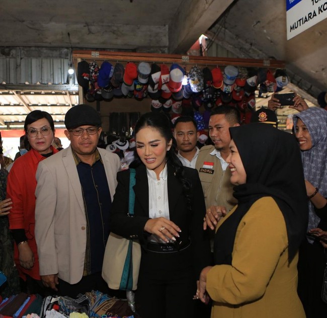 Ibu empat anak ini bergaya formal mengenakan setelan blazer dan celana hitam dipadu kemeja putih. Ia juga tampil full-makeup dan rambut dikuncir tengah serta ditata bergelombang. Foto: Instagram/@krisdayantilemos