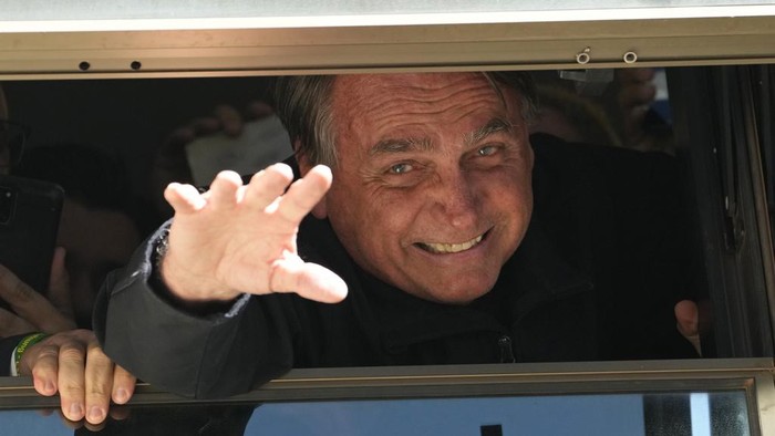 Brazils former President Jair Bolsonaro waves to supporters at the Liberal Partys headquarters in Brasilia, Brazil, Thursday, March 30, 2023. Bolsonaro arrived back in Brazil on Thursday after a three-month stay in Florida, seeking a new role on the political scene. (AP Photo/Eraldo Peres)