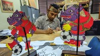 Perajin wayang kulit Margono menggambar pola wayang berkarakter maskot Piala Dunia U-20 Bacuya untuk souvenir di sentra Industri Kecil Menengah (IKM) Semanggi Harmoni, Solo, Jawa Tengah, Kamis (30/3/2023).