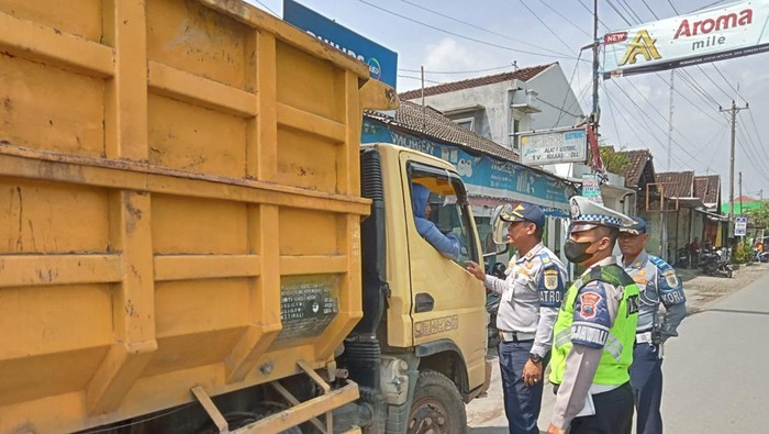 Petugas menyetop truk muatan tanah uruk yang melintas di sekitar Stasiun Delanggu, Klaten, Jumat (31/3/2023).