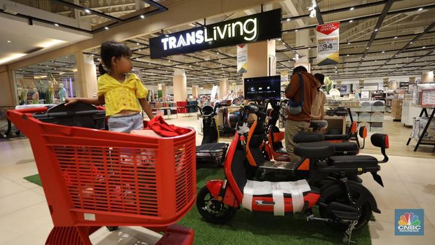 Seorang pengunjung Transmart Cempaka Putih mencoba sepeda listrik pada Rabu (15/3/2023). (CNBC Indonesia/Tri Susilo)