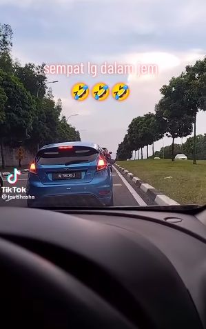 Wanita nyambi potong kacang panjang saat tejebak macet