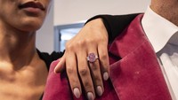 Seorang wanita berpose dengan berlian merah muda 10,57 karat di Sothebys, di New York, Senin (27/3/2023).