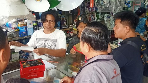 Pemilik Toko Basis Utama, Wayan Sutrisna saat melayani pembeli STB, Sabtu (1/4/2023).