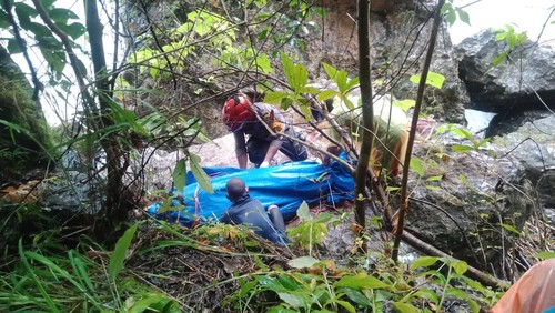 Polisi dibantu warga mengevakuasi jasad Wilhelmina Dahut (70) dari atas bebatuan di pinggir Sungai Wae Raho, di Kampung Heak, Desa Golo Ndeweng, Kecamatan Lembor, Manggarai Barat, NTT, Jumat (31/3/2023).