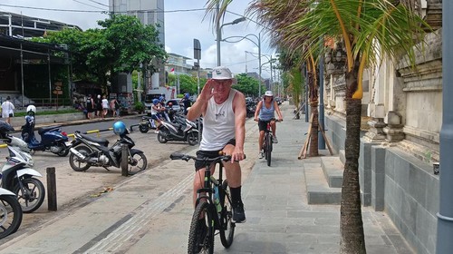 Turis asing bersepeda di trotoar Pantai Kuta, Sabtu (1/4/2023).