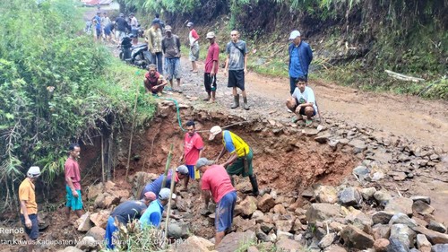Warga bergotong royong memperbaiki ruas jalan kabupaten yang amblas di Wae Pahang, Dusun Lait, Desa Wajur, Kecamatan Kuwus Barat, Kabupaten Manggarai Barat, Nusa Tenggara Timur (NTT), Sabtu (1/4/2023). (Foto: Istimewa)