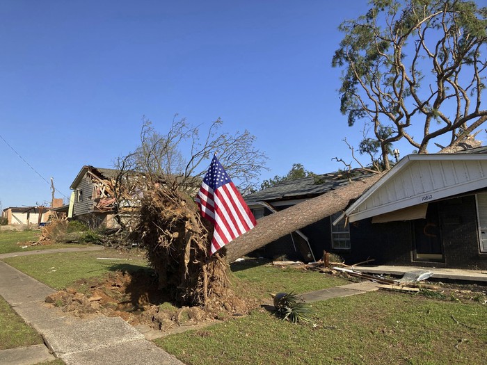 A fallen tree damages a house after a storm in Little Rock, Ark., on Saturday, April 1, 2023.  Unrelenting tornadoes that tore through parts of the South and Midwest that shredded homes and shopping centers. (AP Photo/Andrew DeMillo)