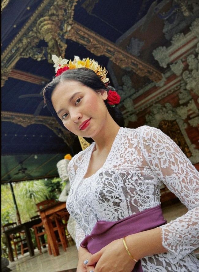 Bintang ‘Wedding Agreement’ ini bergaya dengan baju kebaya khas Bali. Ia pun tampil anggun mengenakan kebaya lace warna putih dipadu kain songket warna ungu tua. Foto: Instagram/@indahpermatas