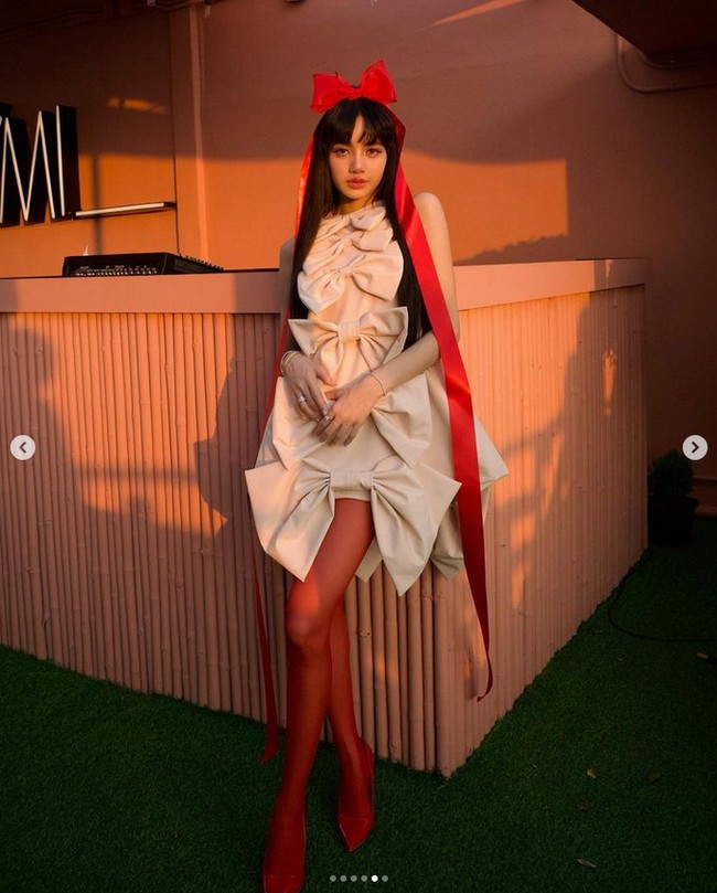 Dalam kesempatan itu, Lisa BLACKPINK memakai gaun mini bertutup pita yang dipadukan dengan stocking dan heels berwarna merah. Kepalanya pun dihiasi aksesori pita serasi. Foto: Instagram
