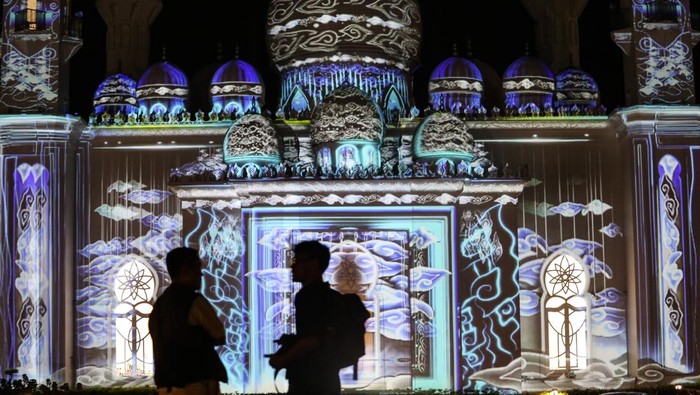 Pengunjung berswafoto dengan latar belakang video mapping yang ditampilkan saat acara Khazanah Fest di Masjid At-Thohir, Depok, Jawa Barat, Minggu (2/4/2023). Masjid At-Thohir yang dibangun sejak tahun 2022 dengan gaya arsitektur klasik modern tersebut menampilkan pertunjukkan video mapping nuansa Ramadhan. ANTARA FOTO/Asprilla Dwi Adha/YU