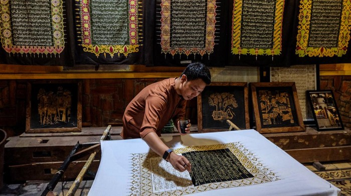 Melihat Pembuatan Batik Tulis Bermotif Ayat Al-Qurβan di Solo Perajin menyelesaikan pewarnaan batik motif ayat Alquran di Mahkota Batik Laweyan, Solo, Jawa Tengah, Jumat (31/3/2023). Batik tulis tersebut selanjutnya dibuat sebagai mushaf untuk mengajak masyarakat belajar menulis, membaca dan memahami Al Quran, sekaligus menarik kunjungan wisatawan di kampung batik setempat. ANTARAFOTO/Maulana Surya/aww.
