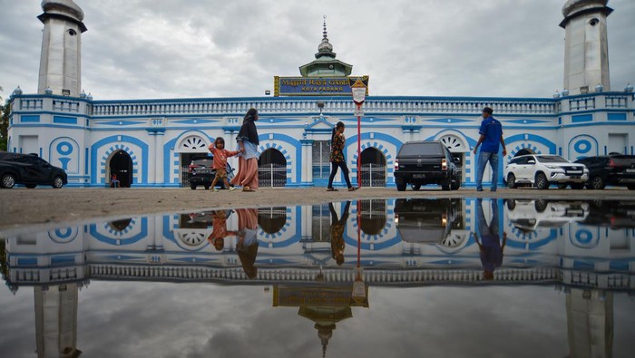 Mengenal Masjid Raya Ganting, Masjid Tertua di kota Padang Warga melintas di depan Masjid Raya Ganting, Kota Padang, Sumatera Barat, Sabtu (1/4/2023). Masjid tertua di Kota Padang yang memiliki kapasitas 2.000 jamaah tersebut dibangun sekitar 1805 dan selesai tahun 1810 dengan arsitektur merepresentasikan akulturasi etnis-etnis di kota itu yang memiliki 25 tiang. ANTARA FOTO/Iggoy el Fitra/hp.