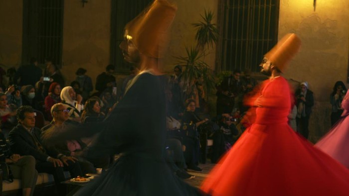 Menyaksikan Tari Sufi, Tarian Religius Penuh Makna Amr el-Toney, at top center, founder of the Mawlawiyah dervish dance troupe, directs dervishes from the Al-Tannoura Egyptian Heritage Dance Troupe, during a religious performance to mark the holy month of Ramadan at the ancient Prince Taz palace in Cairo, Egypt, Wednesday, March 29, 2023. Muslims throughout the world are celebrating Ramadan, the holiest month in the Islamic calendar, refraining from eating, drinking, smoking and sex from sunrise to sunset. (AP Photo/Amr Nabil)