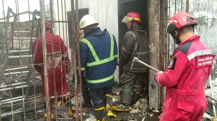 Petugas damkar memadamkan api di sebuah minimarket Jalan Veteran Utara, Makassar.