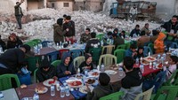 Penduduk setempat yang terkena dampak gempa 6 Februari menghadiri jamuan buka puasa massal Ramadan di kota Atareb di pedesaan barat provinsi Aleppo yang dikuasai pemberontak, Jumat (31/3/2023). 