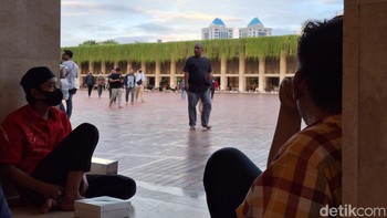 Duduk-duduk santai di pelataran masjid bisa menjadi alternatif sembari melihat keindahan bangunan Masjid Istiqlal dan aktivitas yang dilakukan pengunjung. Foto: Adi Fida Rahman/detikINET