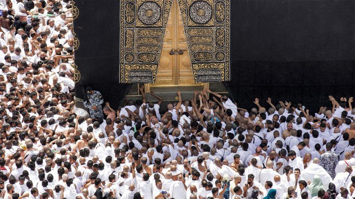 Muslim worshippers reach for a blessing to touch the Kaaba, Islam's holiest shrine, at the Grand Mosque in the holy city of Mecca during the second Friday prayers in the holy month of Ramadan on March 31, 2023. (Photo by Abdel Ghani BASHIR / AFP) (Photo by ABDEL GHANI BASHIR/AFP via Getty Images)