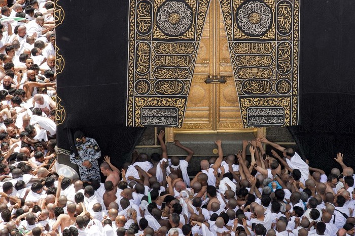 Muslim worshippers reach for a blessing to touch the Kaaba, Islams holiest shrine, at the Grand Mosque in the holy city of Mecca during the second Friday prayers in the holy month of Ramadan on March 31, 2023. (Photo by Abdel Ghani BASHIR / AFP) (Photo by ABDEL GHANI BASHIR/AFP via Getty Images)