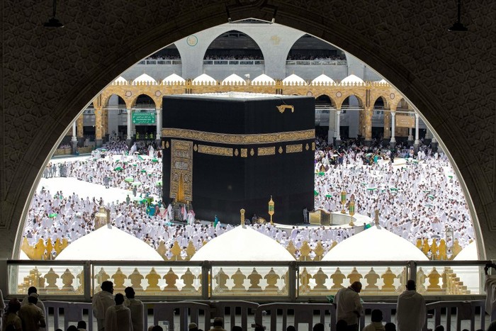 Muslim worshippers reach for a blessing to touch the Kaaba, Islams holiest shrine, at the Grand Mosque in the holy city of Mecca during the second Friday prayers in the holy month of Ramadan on March 31, 2023. (Photo by Abdel Ghani BASHIR / AFP) (Photo by ABDEL GHANI BASHIR/AFP via Getty Images)
