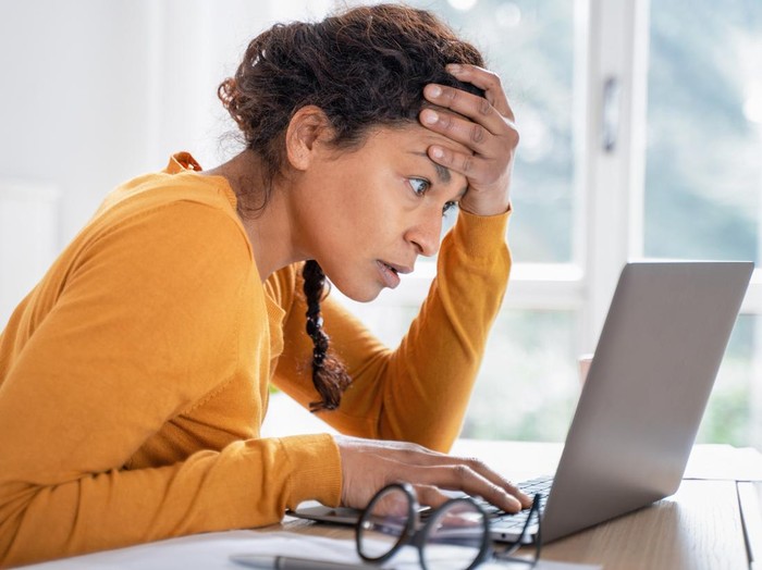 Black woman worried reading bad news on internet
