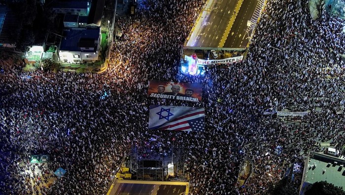 An aerial view shows protesters displaying a sign depicting the faces of Israeli Prime Minister Benjamin Netanyahu, Security Minister Itamar Ben-Gvir and Finance Minister Bezalel Smotrich, during a demonstration against Israel's nationalist coalition government's judicial overhaul, in Tel Aviv, Israel April 1, 2023. REUTERS/Ilan Rosenberg     TPX IMAGES OF THE DAY
