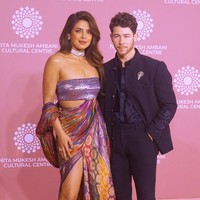 Priyanka Chopra hadir ditemani Nick Jonas. Aktris Bollywood ini tampil seksi dengan sari berhias benang emas. Dia memadukan kain sari bersama crop top silver metalik yang menambah kesan glamor. Foto: Getty Images