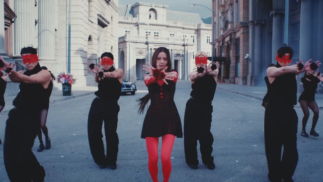 Rose BLACKPINK ikut mendampingi Jisoo saat syuting video klip FLOWER memakai gaun bernuansa hitam dan merah. Penata gayanya mengkombinasikan tanktop merah, gaun jaring-jaring, stocking, dan manset seharga Rp 1,8 jutaan. Foto: dok. YouTube BLACKPINK