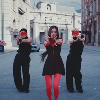 Rose BLACKPINK ikut mendampingi Jisoo saat syuting video klip FLOWER memakai gaun bernuansa hitam dan merah. Penata gayanya mengkombinasikan tanktop merah, gaun jaring-jaring, stocking, dan manset seharga Rp 1,8 jutaan. Foto: dok. YouTube BLACKPINK