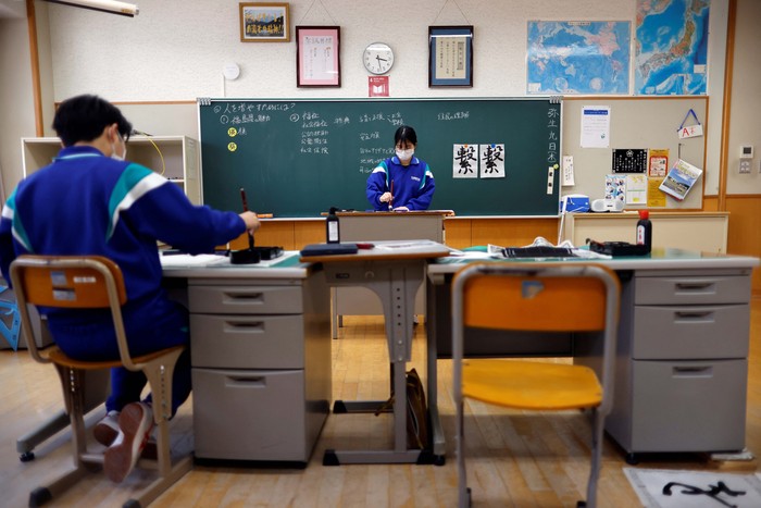Eita Sato, 15, and Aoi Hoshi, 15, who are the only two students at Yumoto Junior High School, attend a Japanese traditional calligraphy class to write a message that will be engraved into the school's closing memorial stone, a few days before their graduation and the institution's closing ceremony, in Ten-ei Village, Fukushima Prefecture, Japan, March 9, 2023. Eita and Aoi, who have been together since three, are the last two graduates of Yumoto Junior High, a public school established in 1947 that in its prosperous years sent out more than 50 graduates, but with only a few enrolments expected in the coming years, the village decided to close the school for good. 