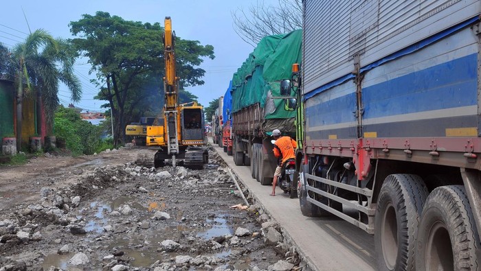Pekerja menggunakan alat berat melakukan perbaikan jalan di jalur Pantura Desa Raci, Batangan, Juwana, Pati, Jawa Tengah, Senin (3/4/2023). Perbaikan jalan sepanjang satu kilometer yang menyebabkan kemacetan sejak empat hari terakhir tersebut ditargetkan selesai H-10 menjelang Lebaran. ANTARA FOTO/Yusuf Nugroho/tom.