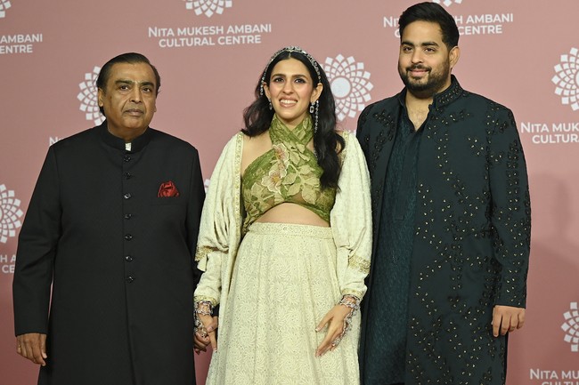 Mukesh Ambani dan putranya Akash, turut menghadiri acara tersebut. Kemeja hitam berkerah nehru menjadi andalan mereka.  (Foto: SUJIT JAISWAL/AFP via Getty Images)