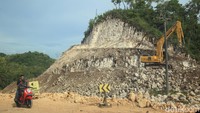 Para pekerja mengoperasikan kendaraan berat untuk membelah gunung kapur dalam proyek Jalur Jalan Lintas Selatan (JJLS) di kawasan Gunungkidul, Yogyakarta, Senin (3/4/2023). 