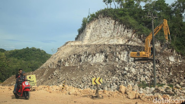 Progres Terkini Pembangunan Jalur Jalan Lintas Selatan Segmen Gunungkidul Para pekerja mengoperasikan kendaraan berat untuk membelah gunung kapur dalam proyek Jalur Jalan Lintas Selatan (JJLS) di kawasan Gunungkidul, Yogyakarta, Senin (3/4/2023).