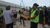 Pekerja membawa jenazah untuk dipindahkan ke tempat pemakaman baru di Kateguhan, Sawit, Boyolali, Jawa Tengah.