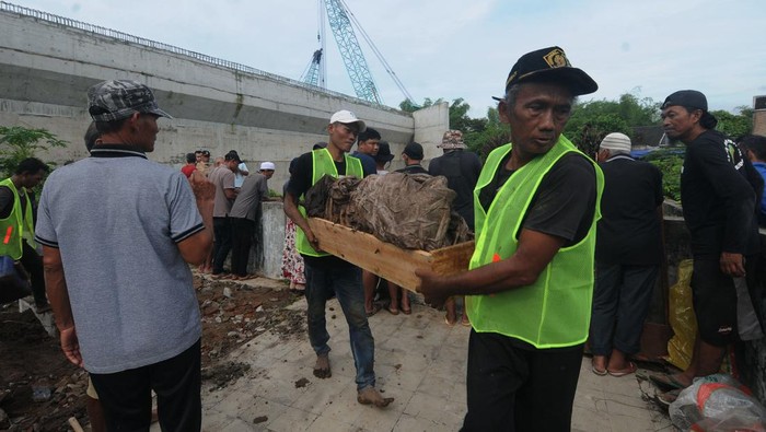 Pekerja membongkar makam di Kateguhan, Sawit, Boyolali, Jawa Tengah, Senin (3/4/2023). Sebanyak 202 makam warga di lahan tersebut dipindahkan ke tempat pemakaman baru untuk pembangunan Jalan Tol Solo-Yogyakarta.