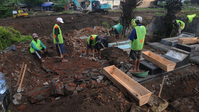 Pekerja membongkar makam di Kateguhan, Sawit, Boyolali, Jawa Tengah, Senin (3/4/2023). Sebanyak 202 makam warga di lahan tersebut dipindahkan ke tempat pemakaman baru untuk pembangunan Jalan Tol Solo-Yogyakarta.